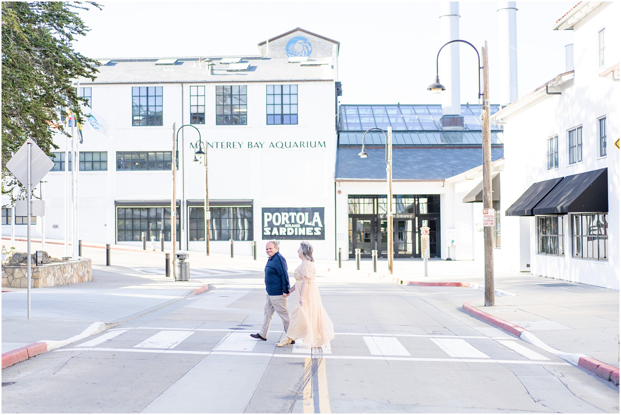 husband and wife walking in front of monterey bay aquarium