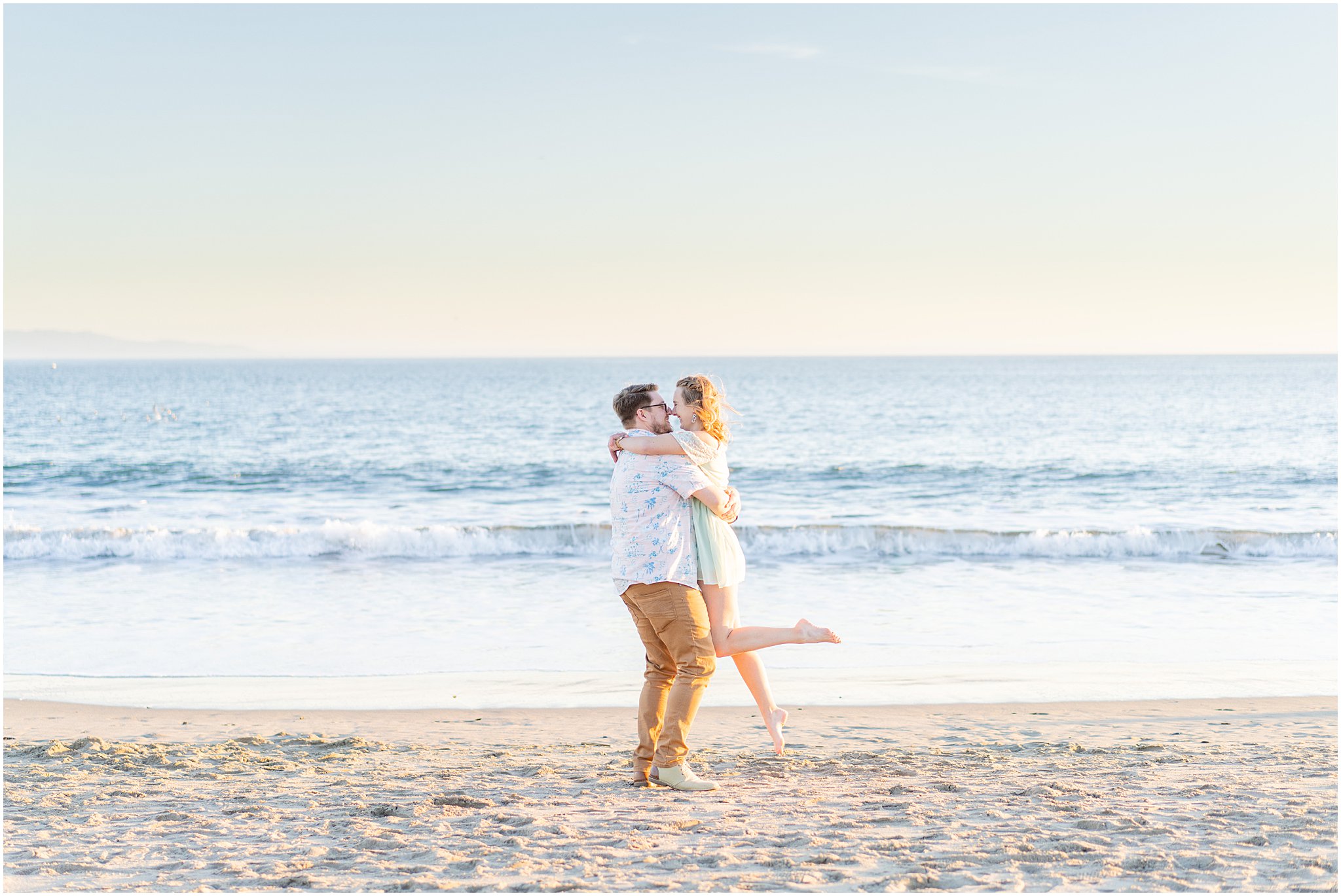engaged couple spinning on the beach