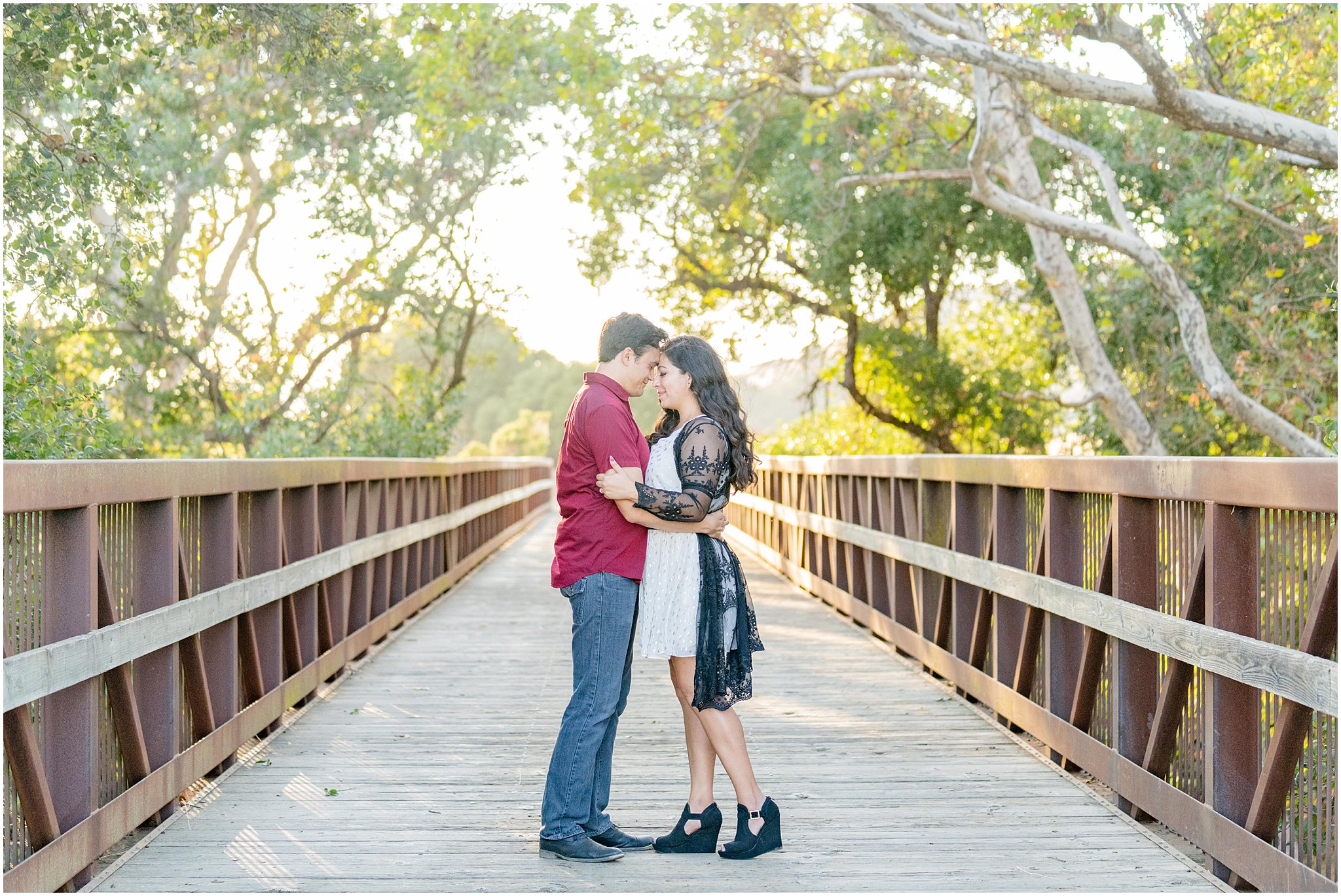 engaged couple standing together on a bridge