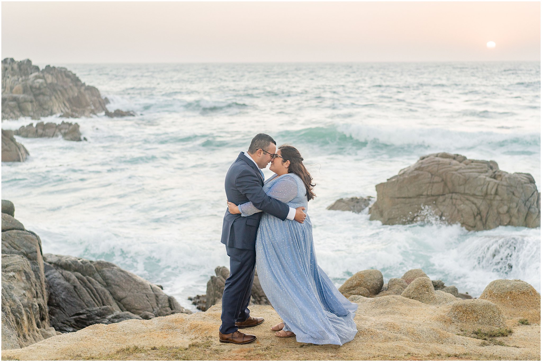 engaged couple in embrace by the ocean