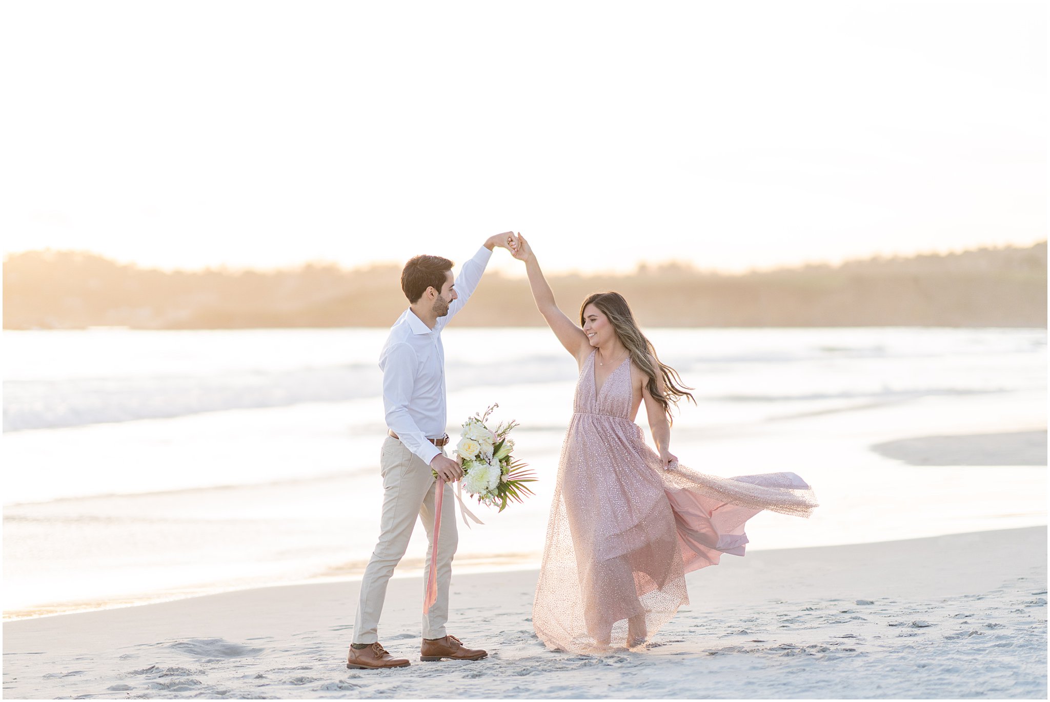 engaged couple dancing on the beach