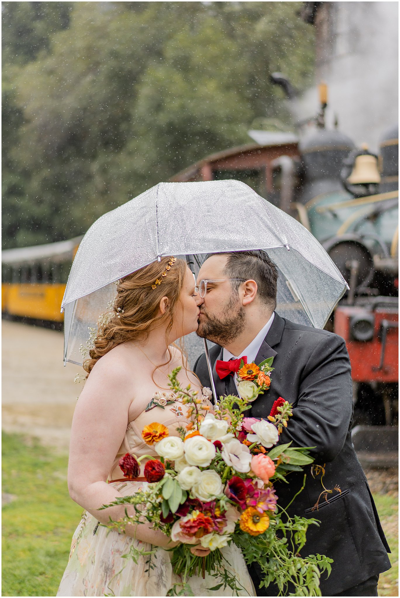 newlyweds kissing under umbrella